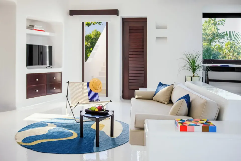 Suite living nook with sofa, coffee table and built-in TV at Hotel Esencia