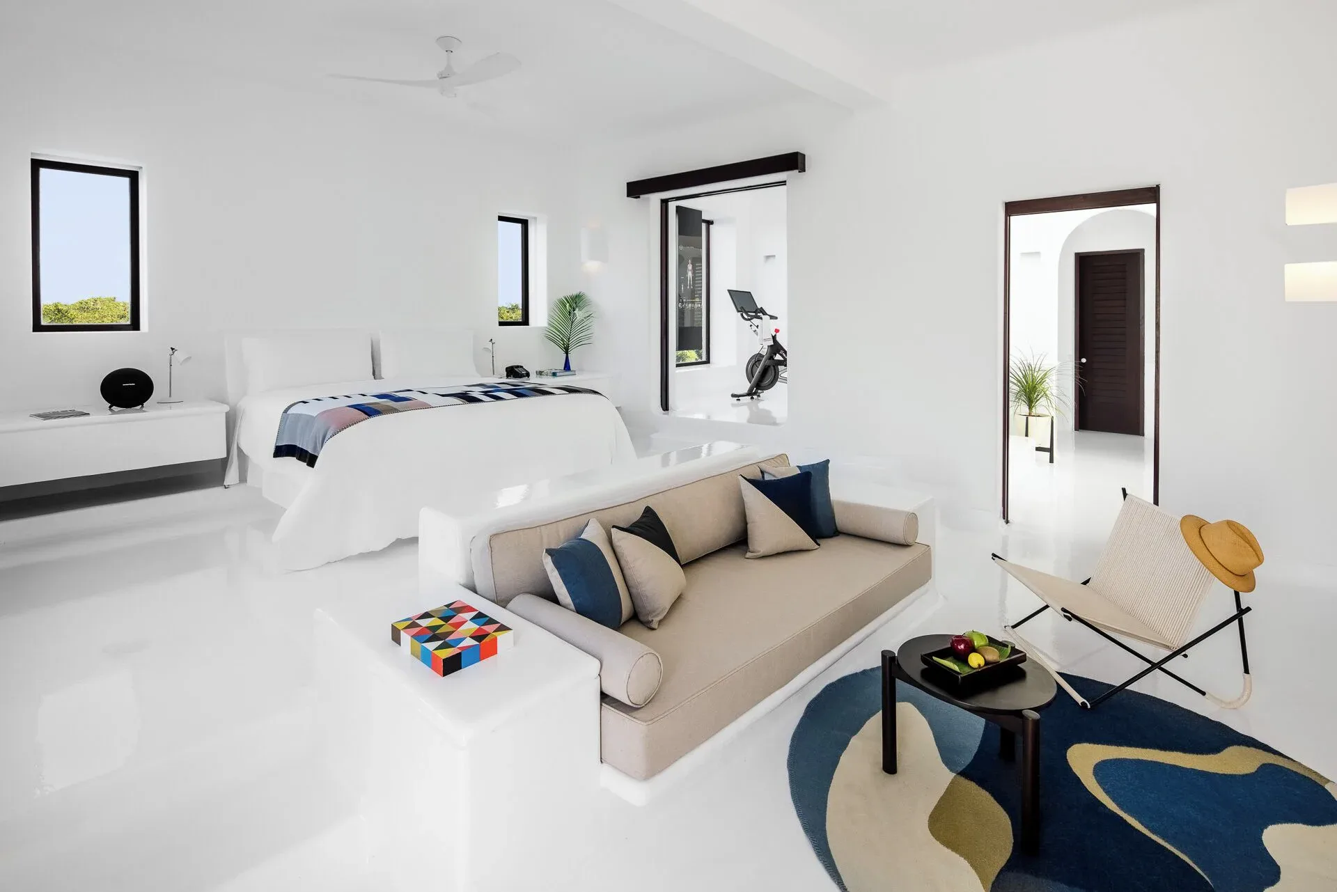 Open-plan suite with king bed, sofa and chair at Hotel Esencia