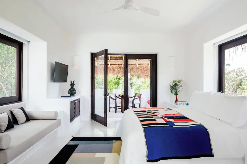 Light-filled Suite (Rooftop Wellness) bedroom with king bed, sofa and terrace at Hotel Esencia.