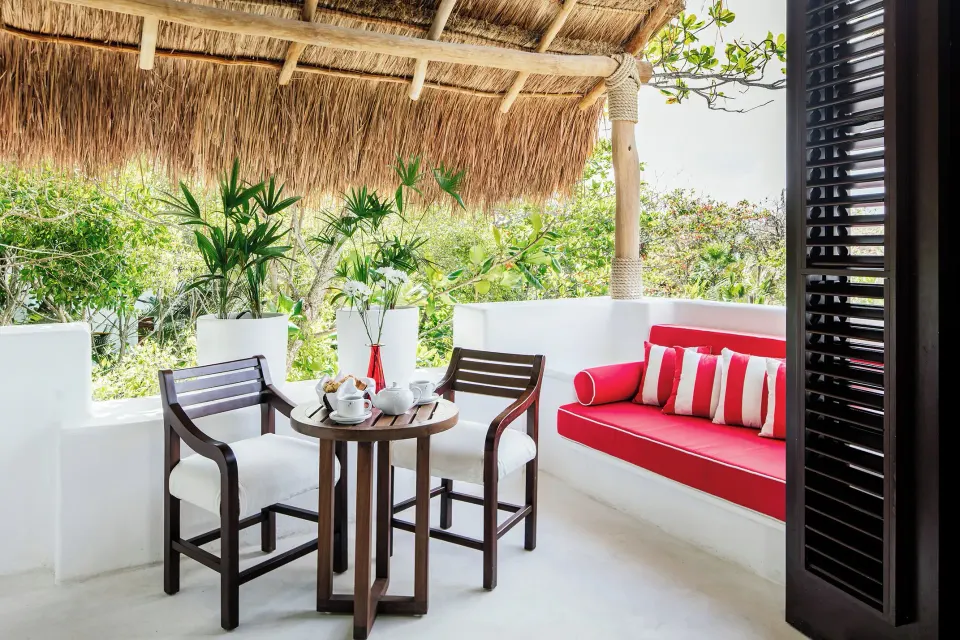 Outdoor seating and red daybed on the Rooftop Wellness Suite terrace at Hotel Esencia