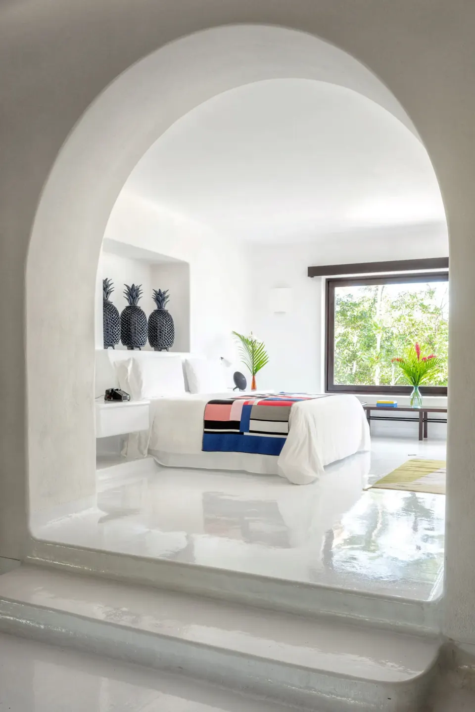 Arched entryway framing The Esencia suite bedroom at Hotel Esencia