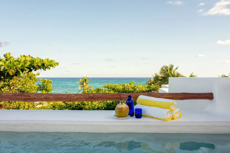 Pool edge with towels and ocean view from The Esencia suite at Hotel Esencia.