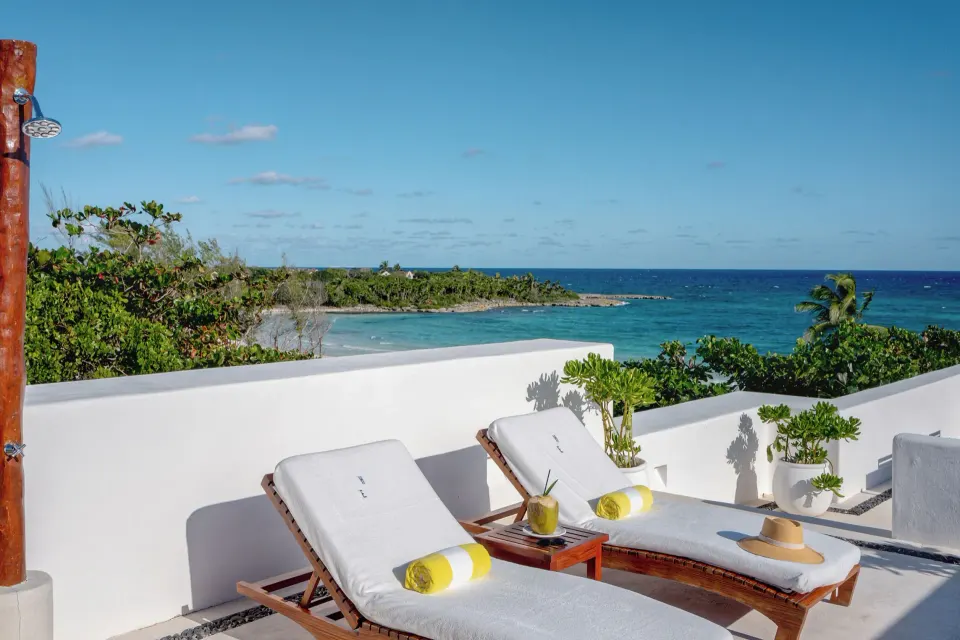 Two sun loungers on a white terrace facing the sea at Hotel Esencia.