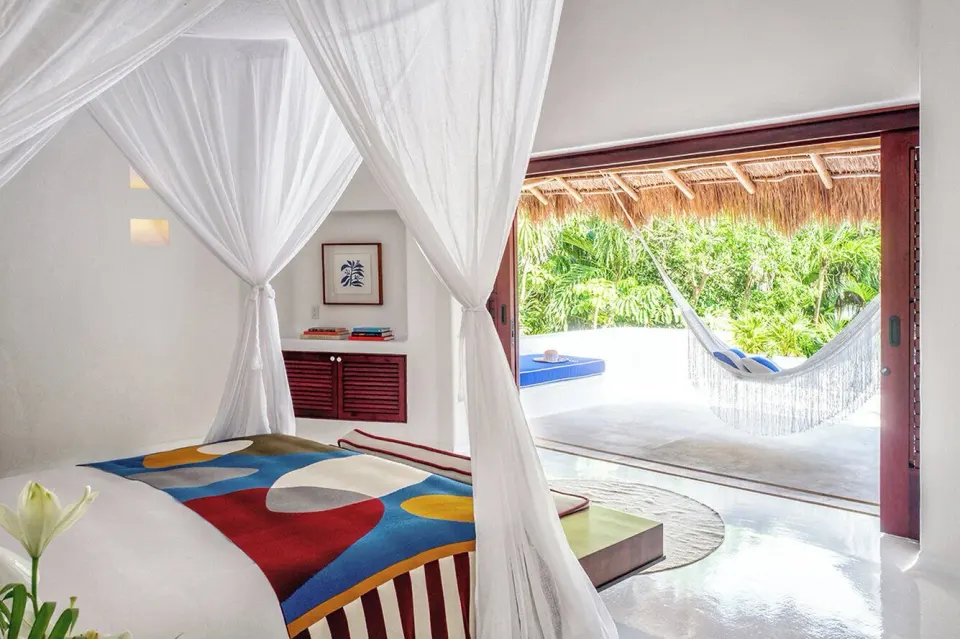Bedroom opening to terrace with hammock and tropical greenery at Hotel Esencia