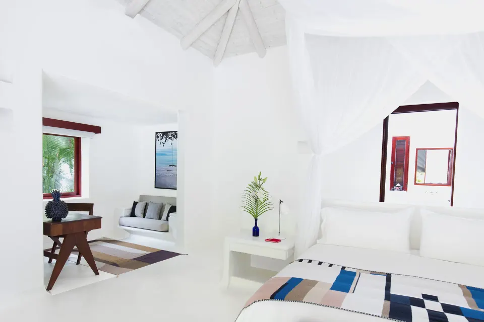 Bright villa bedroom and workspace with high ceilings and white decor at Hotel Esencia