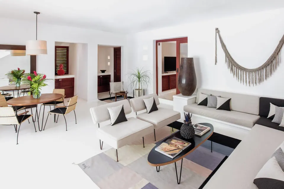 Bright villa living room with white sofas and dining table at Hotel Esencia.
