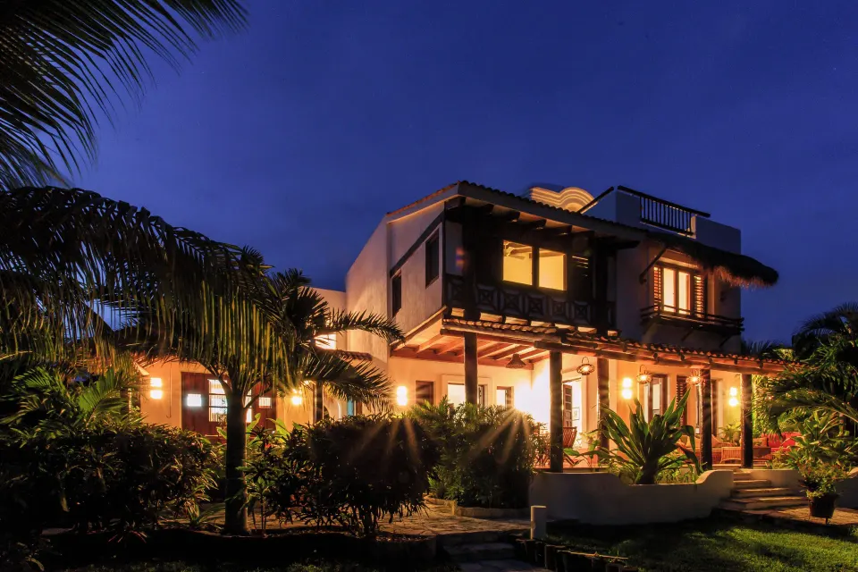 Illuminated two-storey villa at dusk on the grounds of Hotel Esencia.