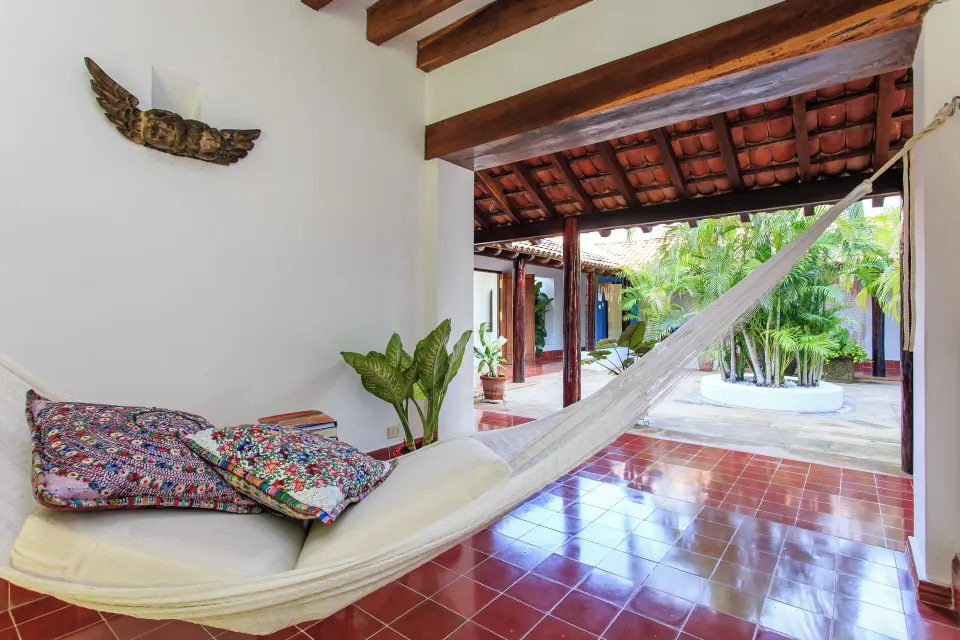 Shaded hammock on a tiled veranda overlooking a central courtyard at Hotel Esencia's Yum-Ha Private Villa.