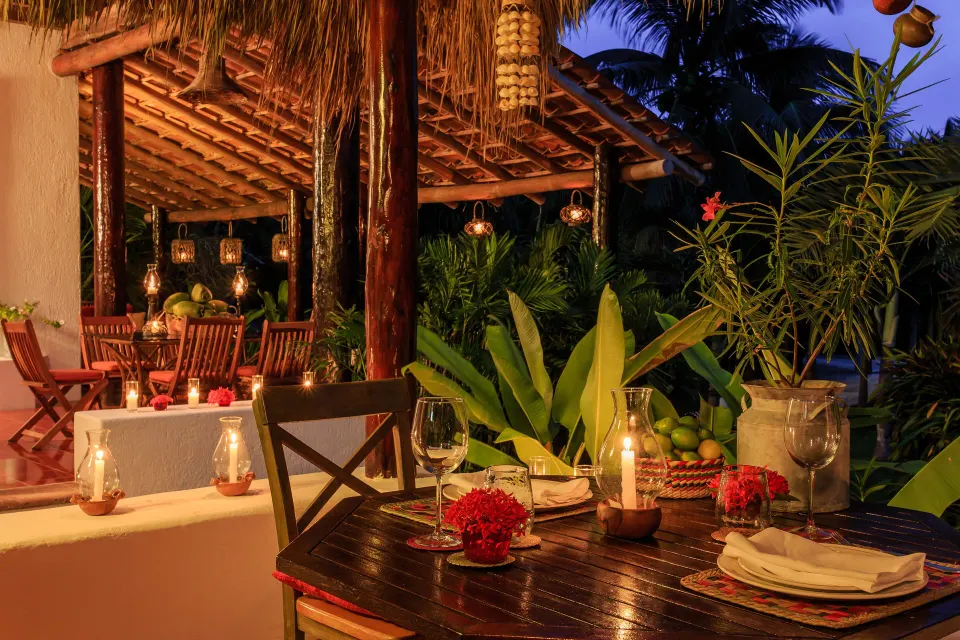 Outdoor covered dining terrace at Yum-Ha Private Villa, Hotel Esencia with candlelit table.