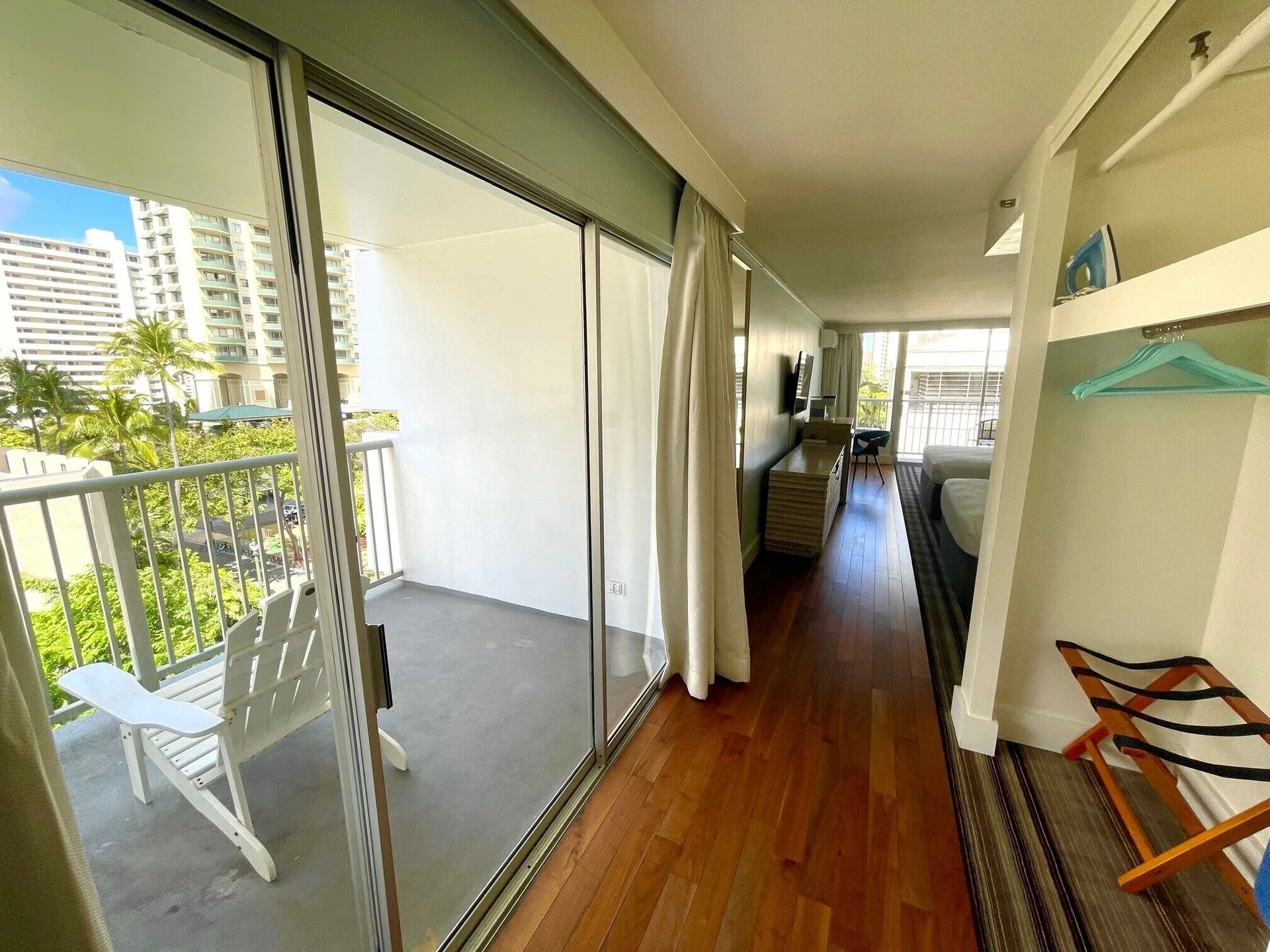Guest room entry with balcony, closet, and wood flooring at Hotel La Croix.