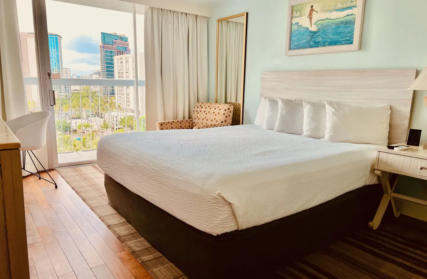 King bed guest room at Hotel La Croix with balcony, city view, desk, and lounge chair.