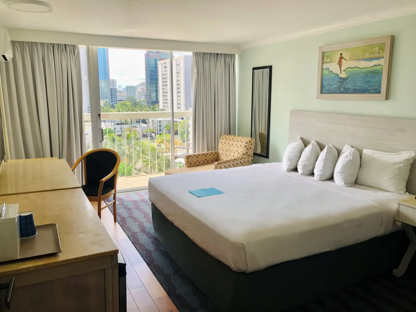King bed guest room with desk, balcony doors, and skyline view at Hotel La Croix.