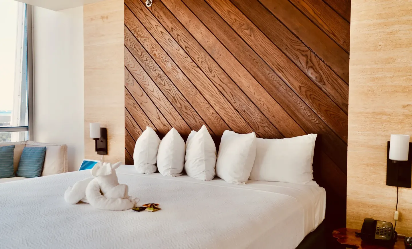 King bed with diagonal wood headboard and towel animal at Hotel La Croix.