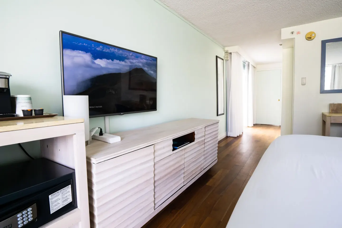 Guest room media wall with TV, safe, and coffee setup at Hotel La Croix.