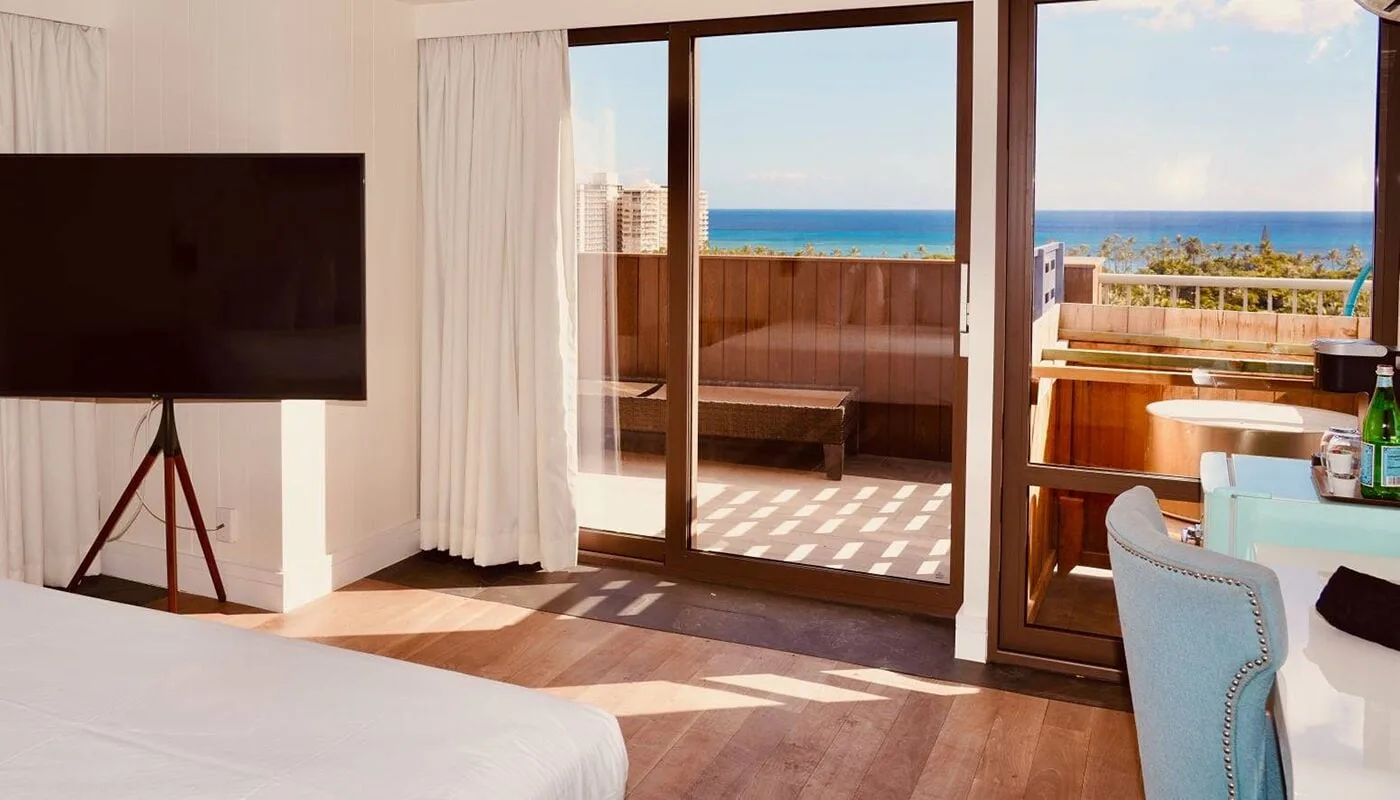 Guest room with bed, TV, terrace, and ocean view at Hotel La Croix.