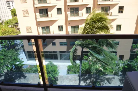Balcony view of palms and nearby buildings from Ali'i Waikiki Two at Hotel La Croix.