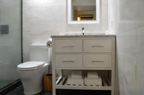 Bathroom vanity, toilet, and shower in Ali'i Waikiki Two at Hotel La Croix.