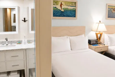 Bed and bathroom vanity in Ali'i Waikiki Two at Hotel La Croix.