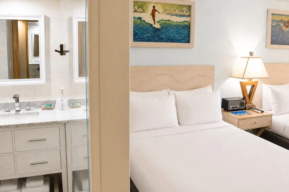 Bed and bathroom vanity in Ali'i Waikiki Two at Hotel La Croix.