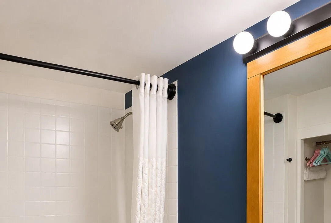 Bronze Room bathroom shower curtain, mirror, and vanity lights at Hotel La Croix.