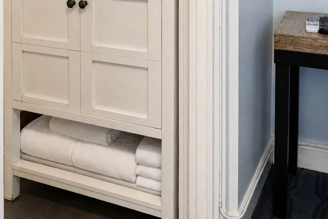 Bronze Room bathroom towels in open vanity storage at Hotel La Croix.