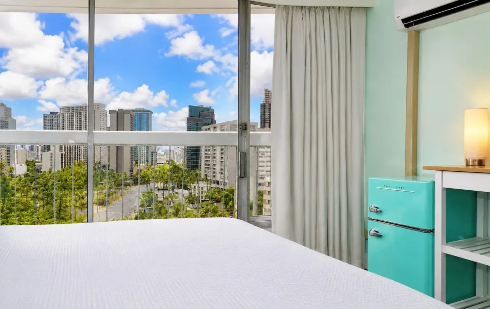 Bronze Room bed and city view through large windows at Hotel La Croix.