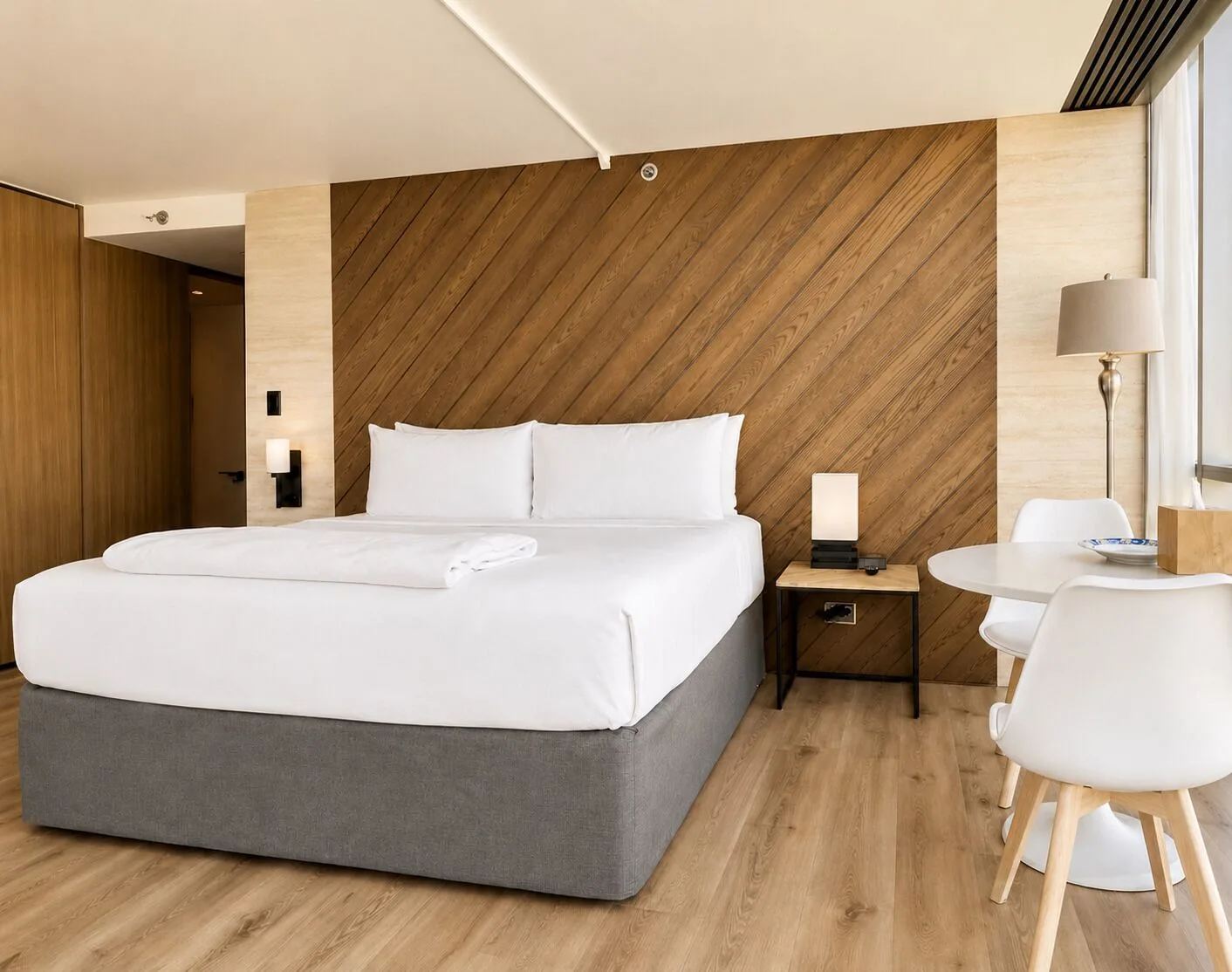 King bed and small dining table in Penthouse Hoku Skyline Direct Oceanview at Hotel La Croix.