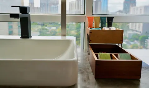 Bathroom sink with bath amenities and a city view in Penthouse Hoku at Hotel La Croix.