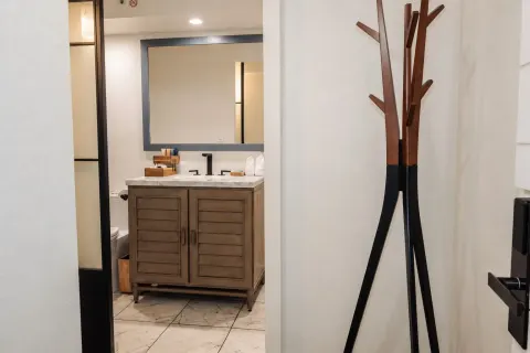 Penthouse Hoku Terrace ADA entry with bathroom vanity and coat stand at Hotel La Croix.