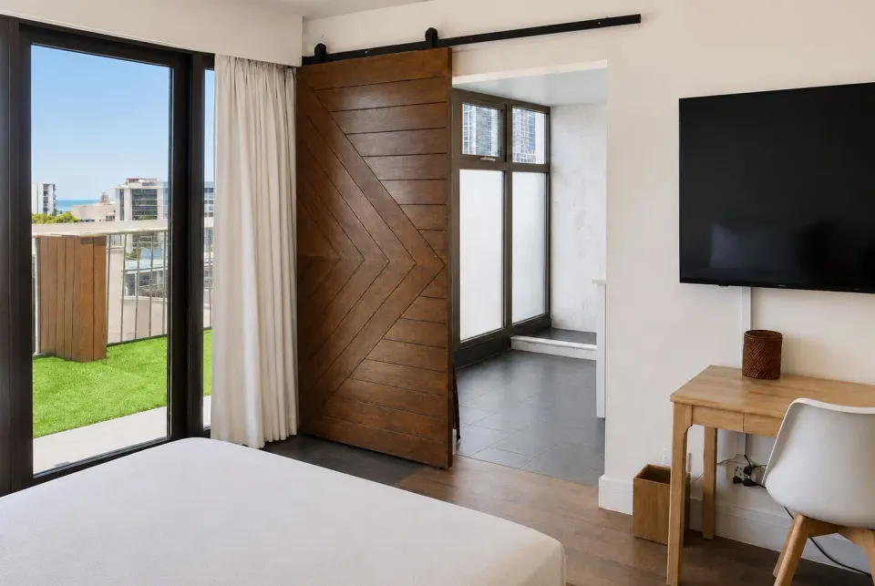 Penthouse Hoku Terrace Oceanview room with bed, terrace doors, desk, and TV at Hotel La Croix.