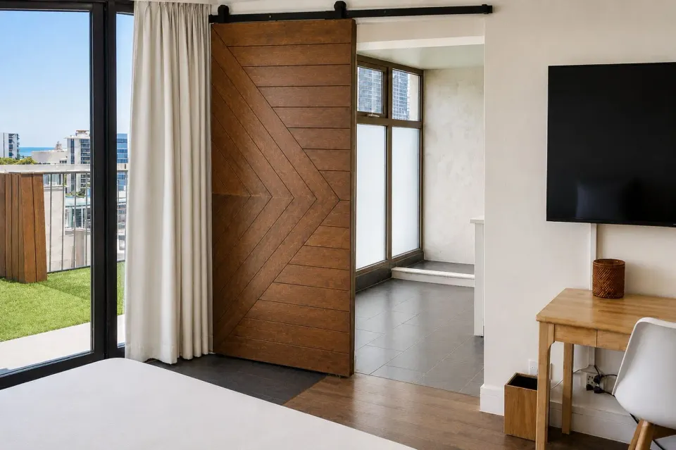 Penthouse Hoku Terrace Oceanview room with terrace doors, barn door, desk, and TV at Hotel La Croix.