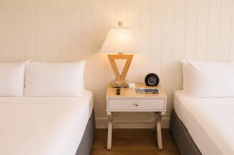 Two beds flank a nightstand with a lit lamp in Penthouse Hoku Terrace Oceanview at Hotel La Croix.