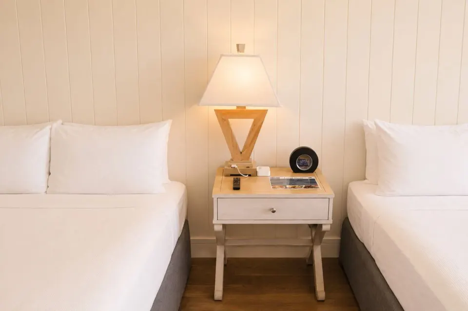 Two beds flank a nightstand with a lit lamp in Penthouse Hoku Terrace Oceanview at Hotel La Croix.