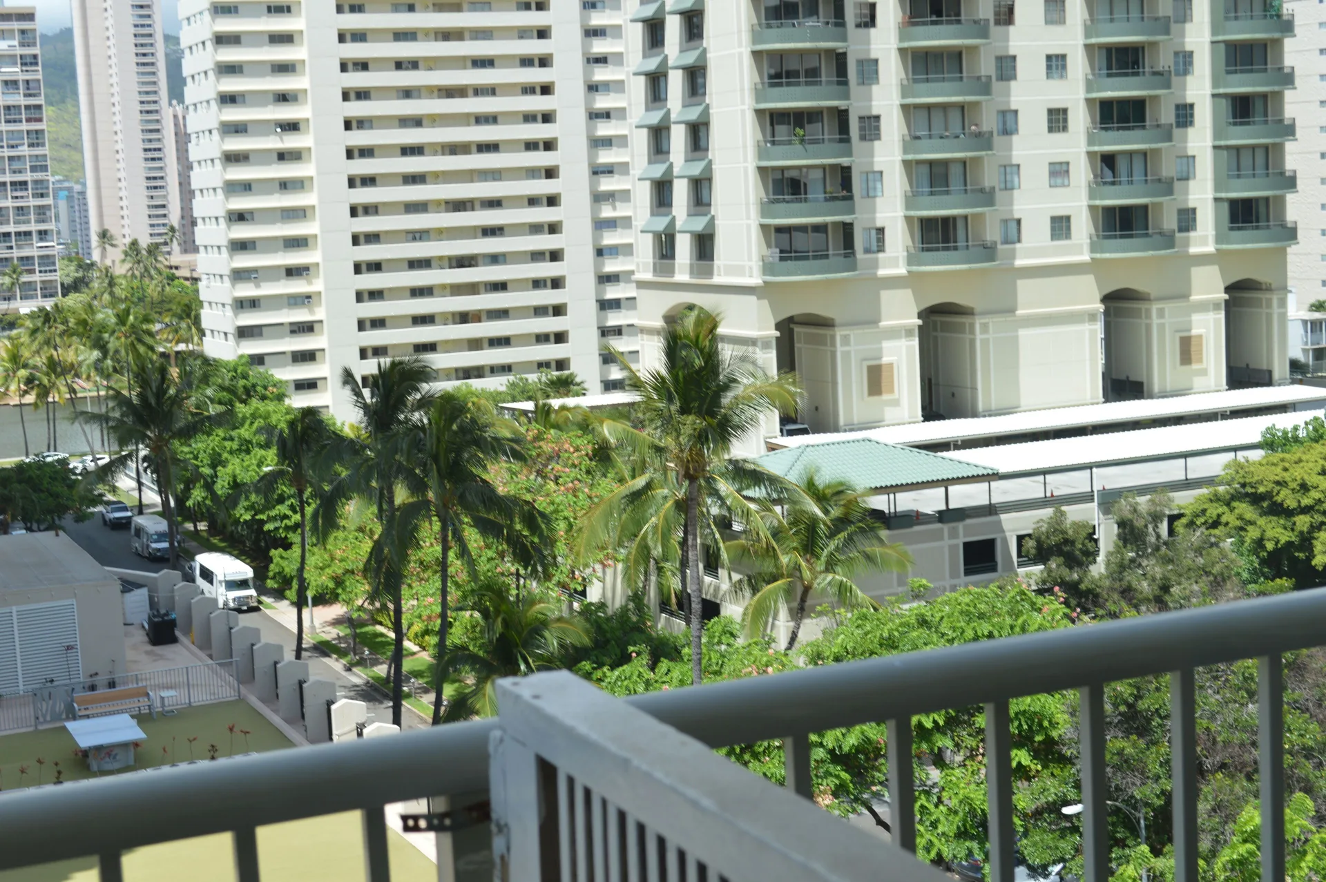 Lanai railing with nearby towers and palms from a Premium Kalakaua Haus room at Hotel La Croix.