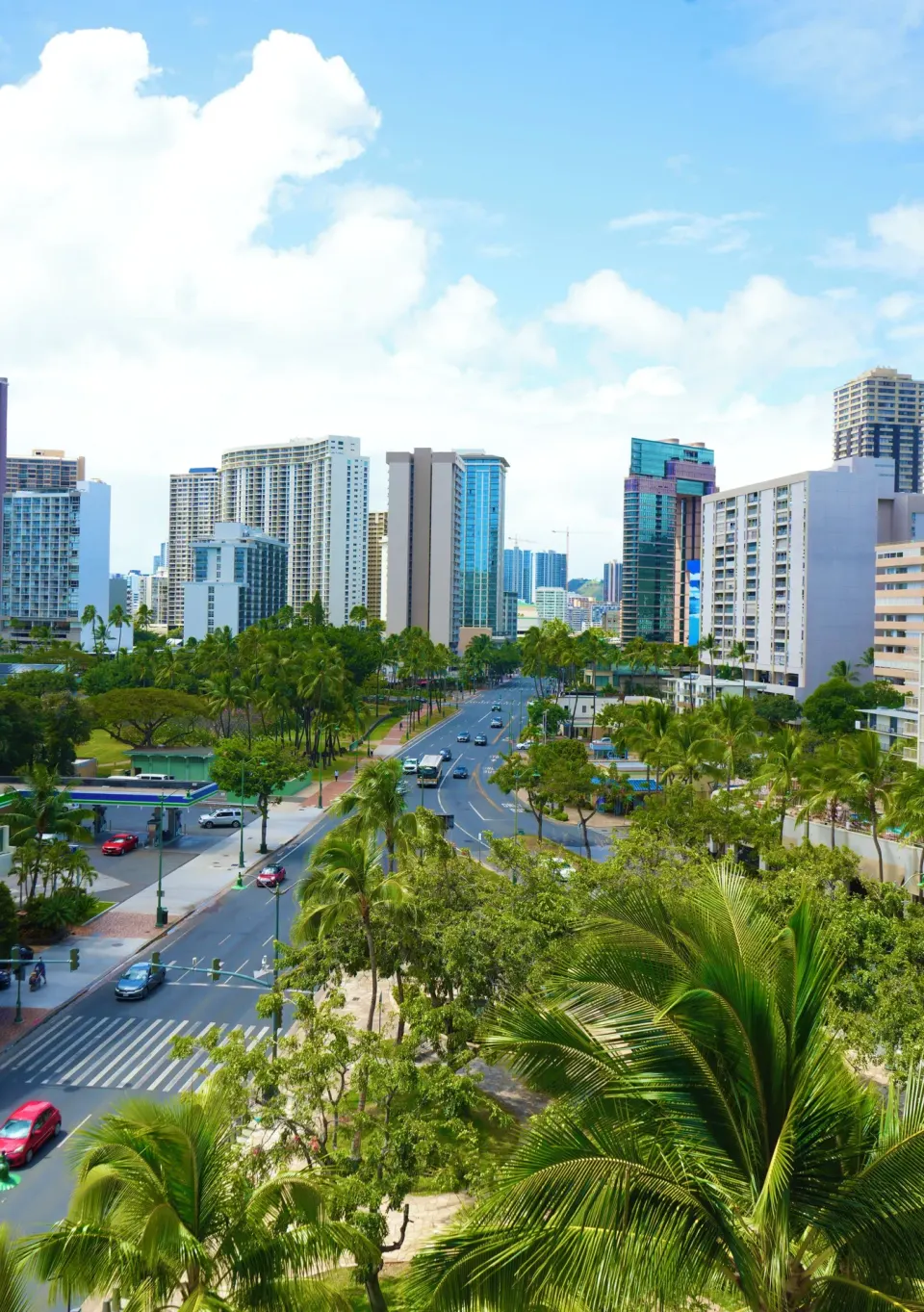 City and palm-lined street view from a Premium Kalakaua Haus room at Hotel La Croix.