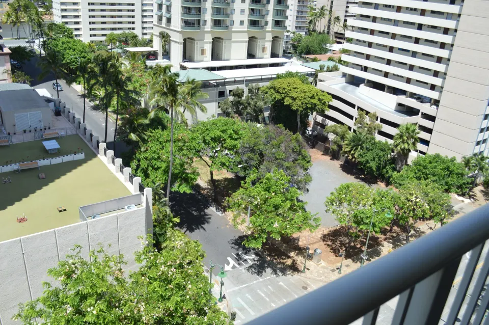 Lanai view of palms and nearby buildings from Hotel La Croix's Premium Kalakaua Haus Corner Two Lanai room.
