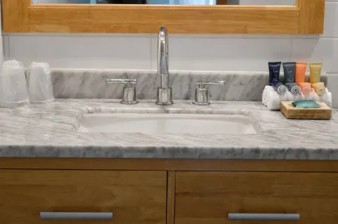 Close-up of the marble-look bathroom sink and toiletries at Hotel La Croix.