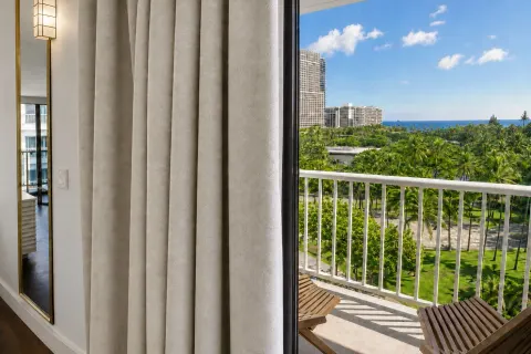 Oceanview lanai with palm trees and skyline in a Premium Kalakaua Haus room at Hotel La Croix.