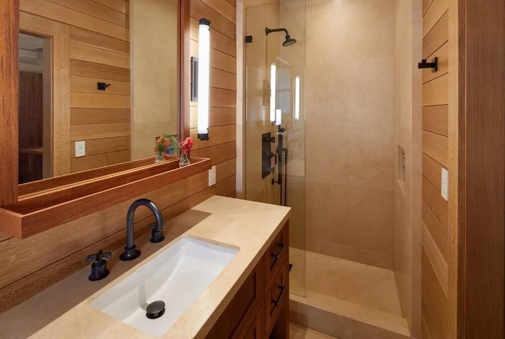 Bathroom at Hotel Lanai with a single vanity, large mirror, and glass shower.