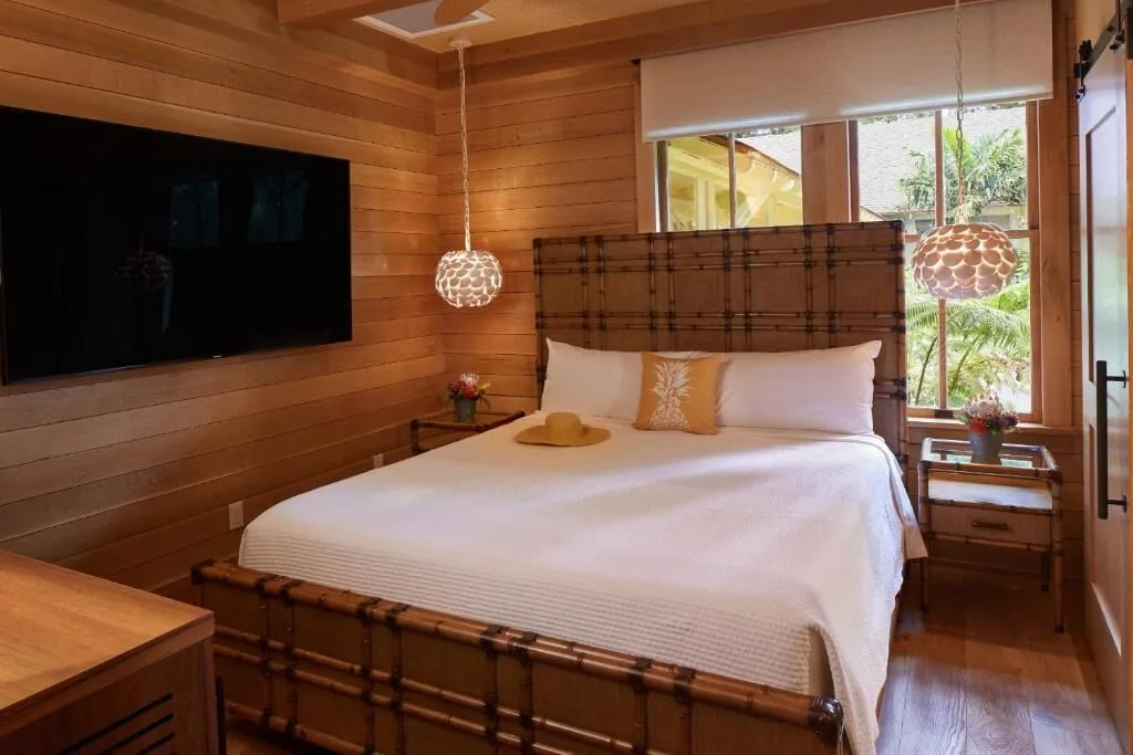 Standard Room king bed with wood walls and window at Hotel Lanai.