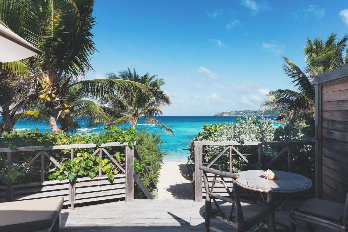 Private deck with table facing the beach and sea at Hotel Manapany.