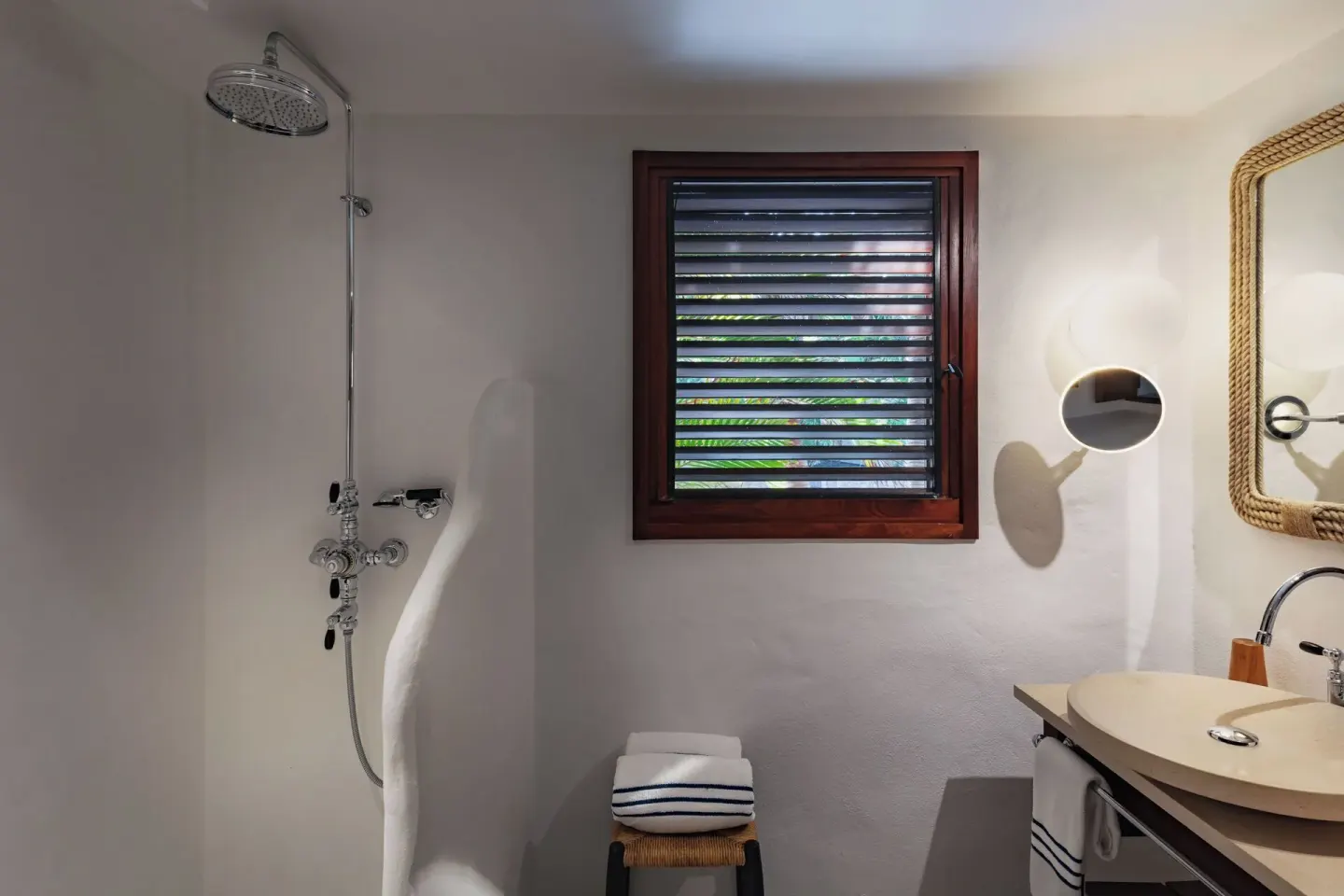 Guest bathroom with open shower and vanity at Hotel Manapany.