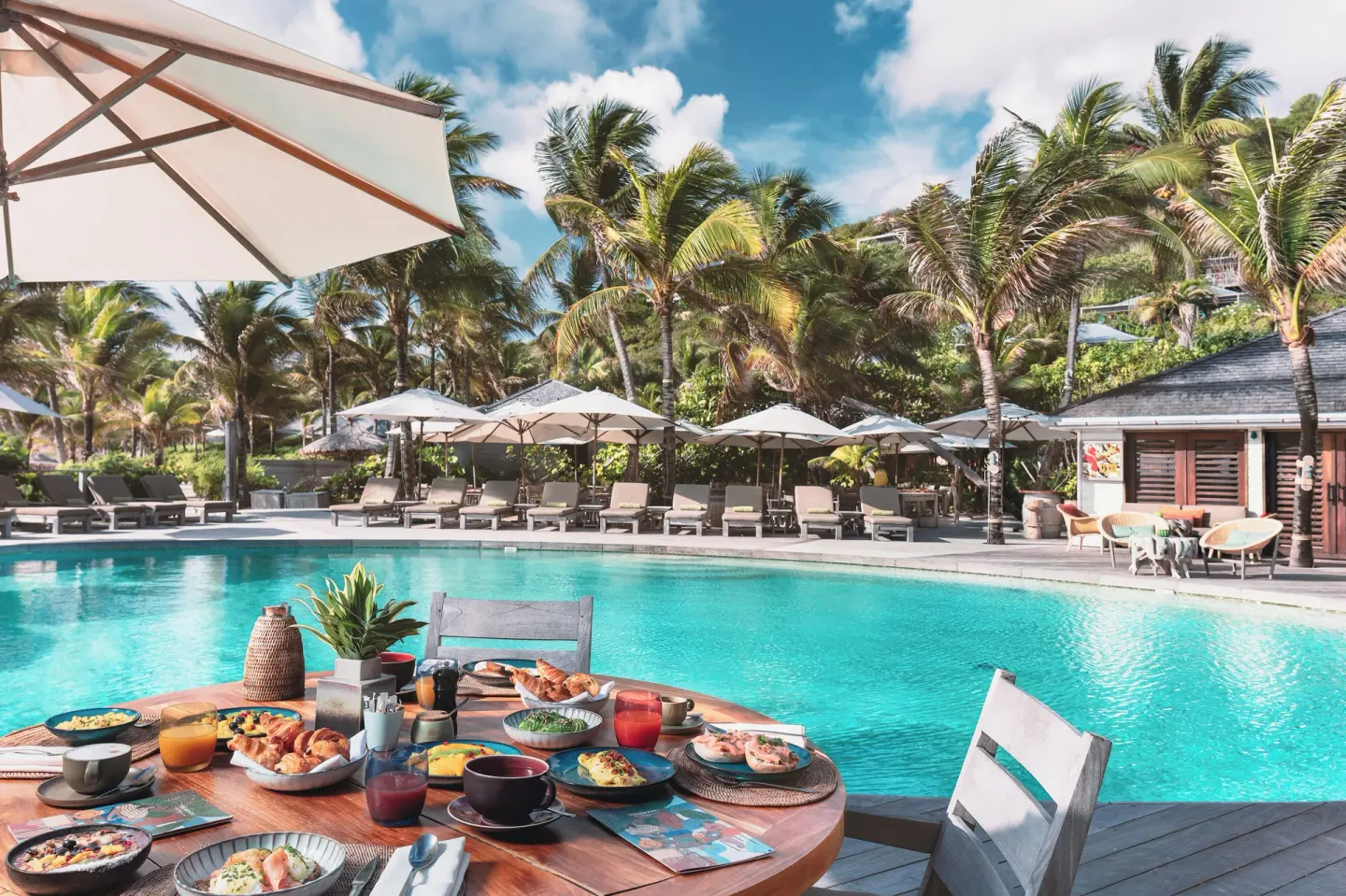 Poolside breakfast table beside the turquoise pool at Hotel Manapany.