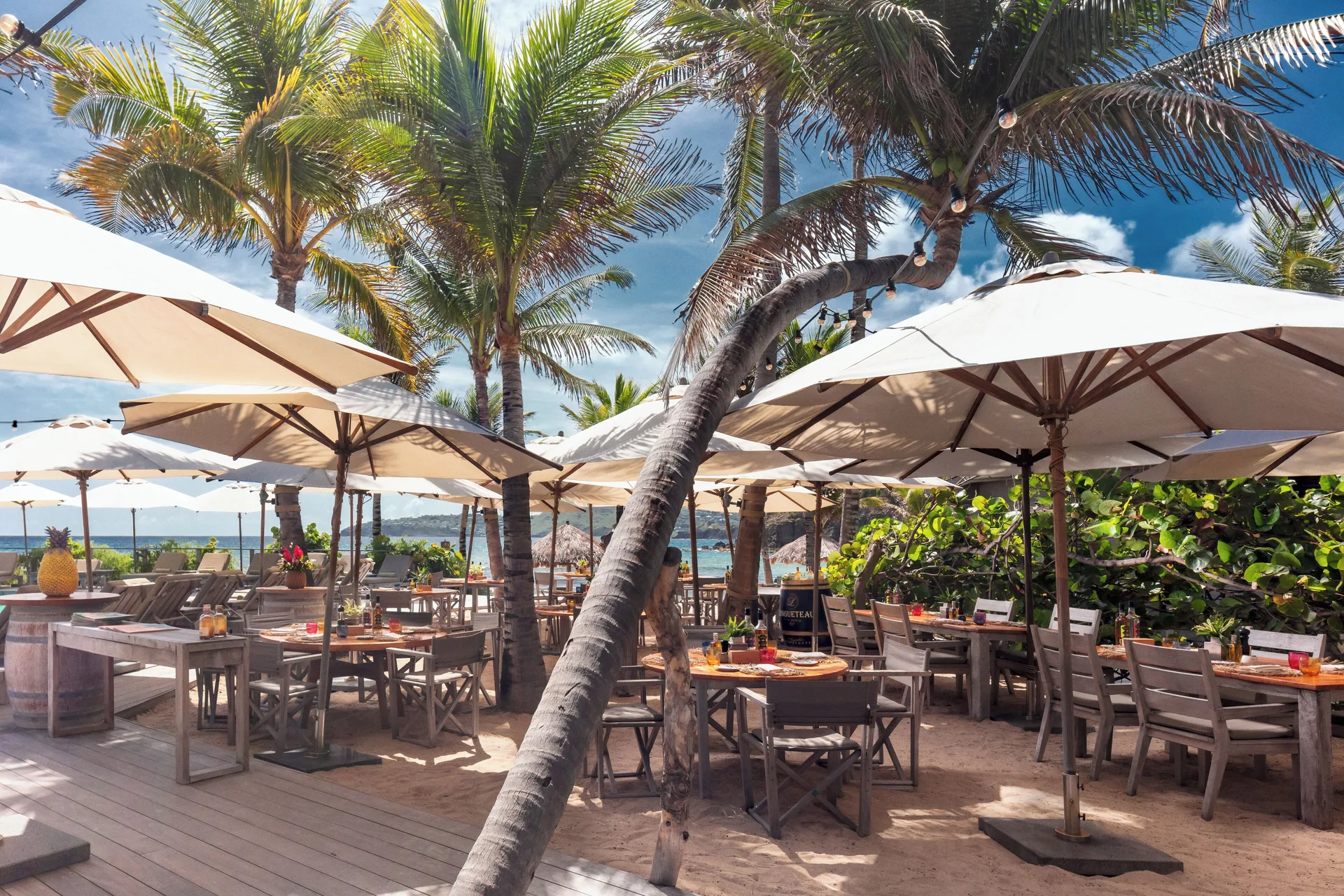 Outdoor beach restaurant seating under umbrellas at Hotel Manapany.