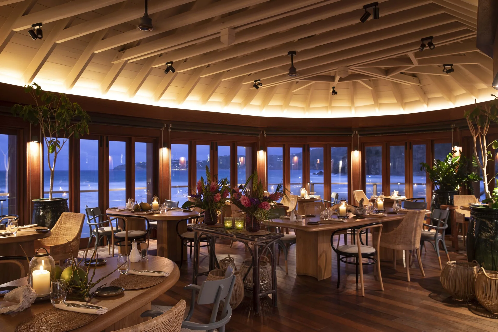 Candlelit oceanfront dining room with set tables at Hotel Manapany.