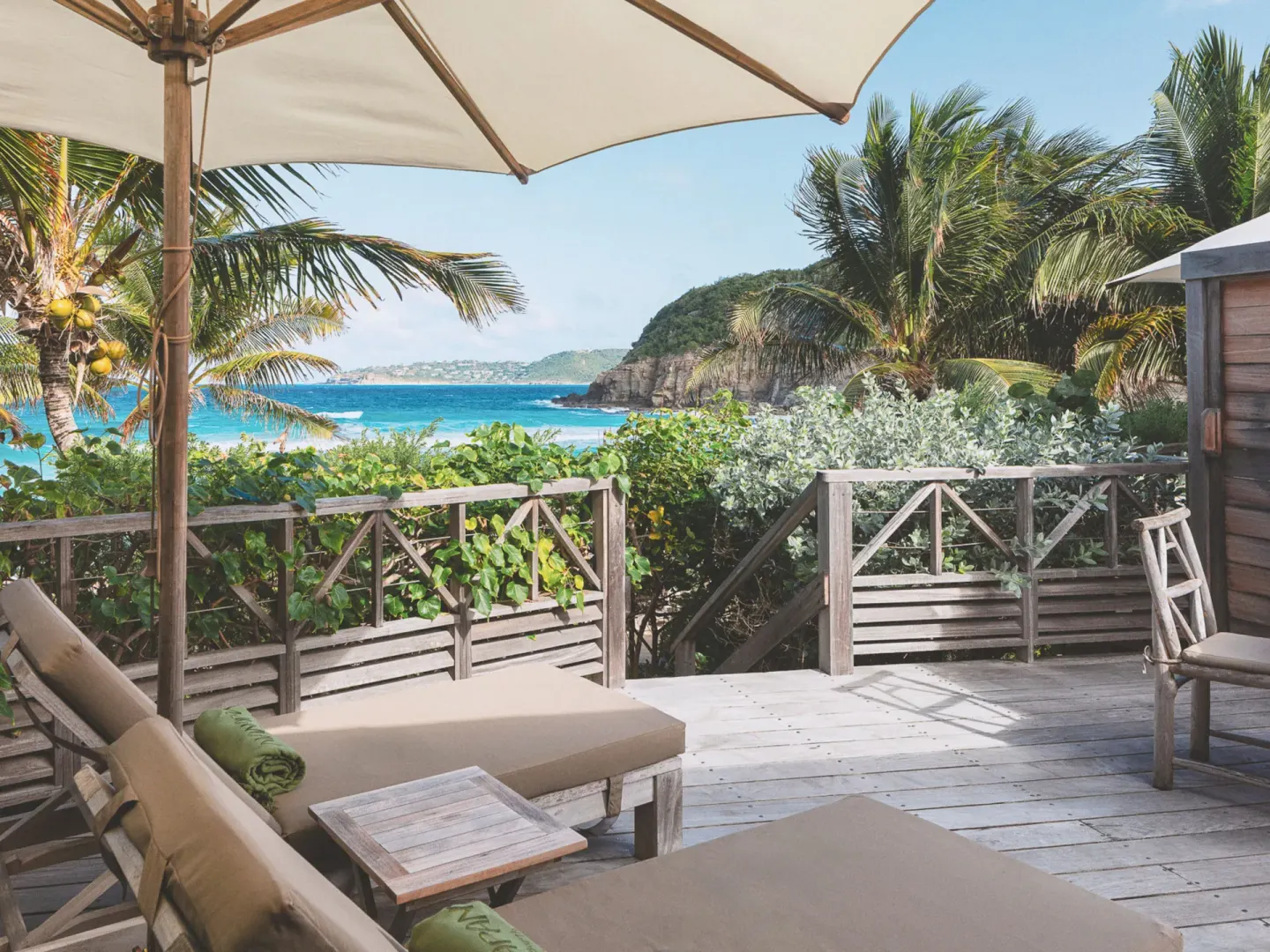 Junior Suite Beach View deck with loungers, umbrella, palms, and sea at Hotel Manapany.
