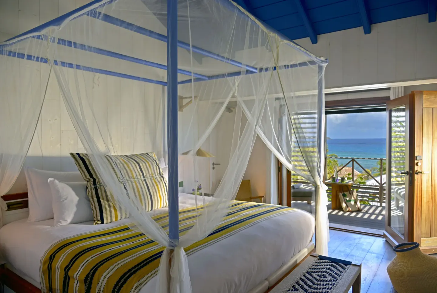 Ocean View room at Hotel Manapany with a canopied bed and balcony facing the sea.