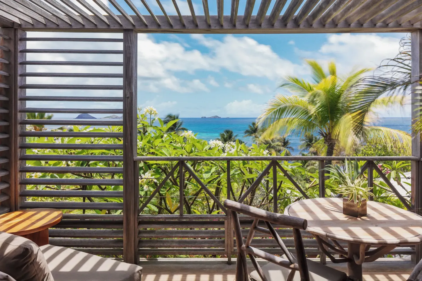 Ocean View room terrace at Hotel Manapany with seating, wooden screens and a turquoise sea view.