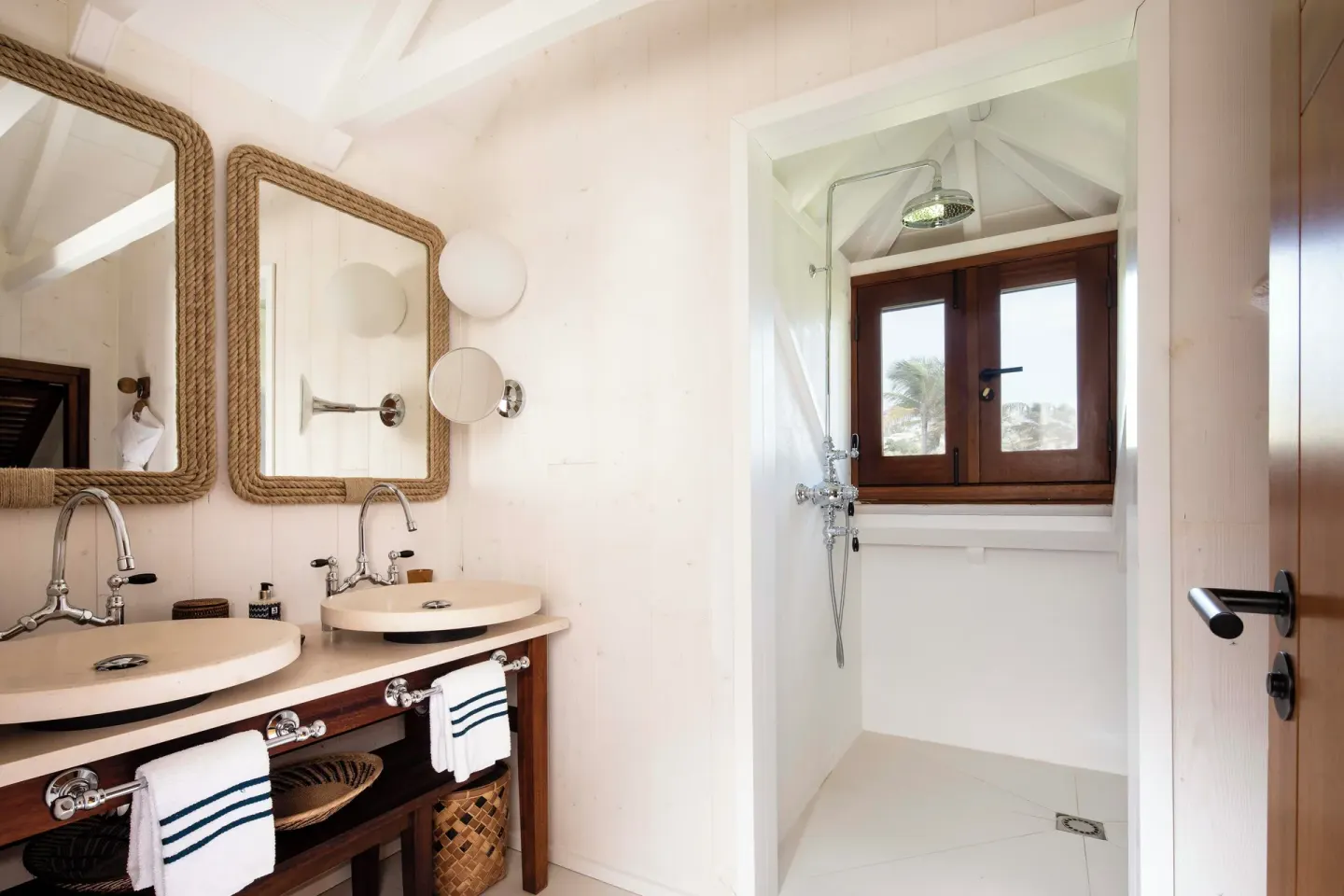 Beachside Suite bathroom with twin sinks and shower at Hotel Manapany.