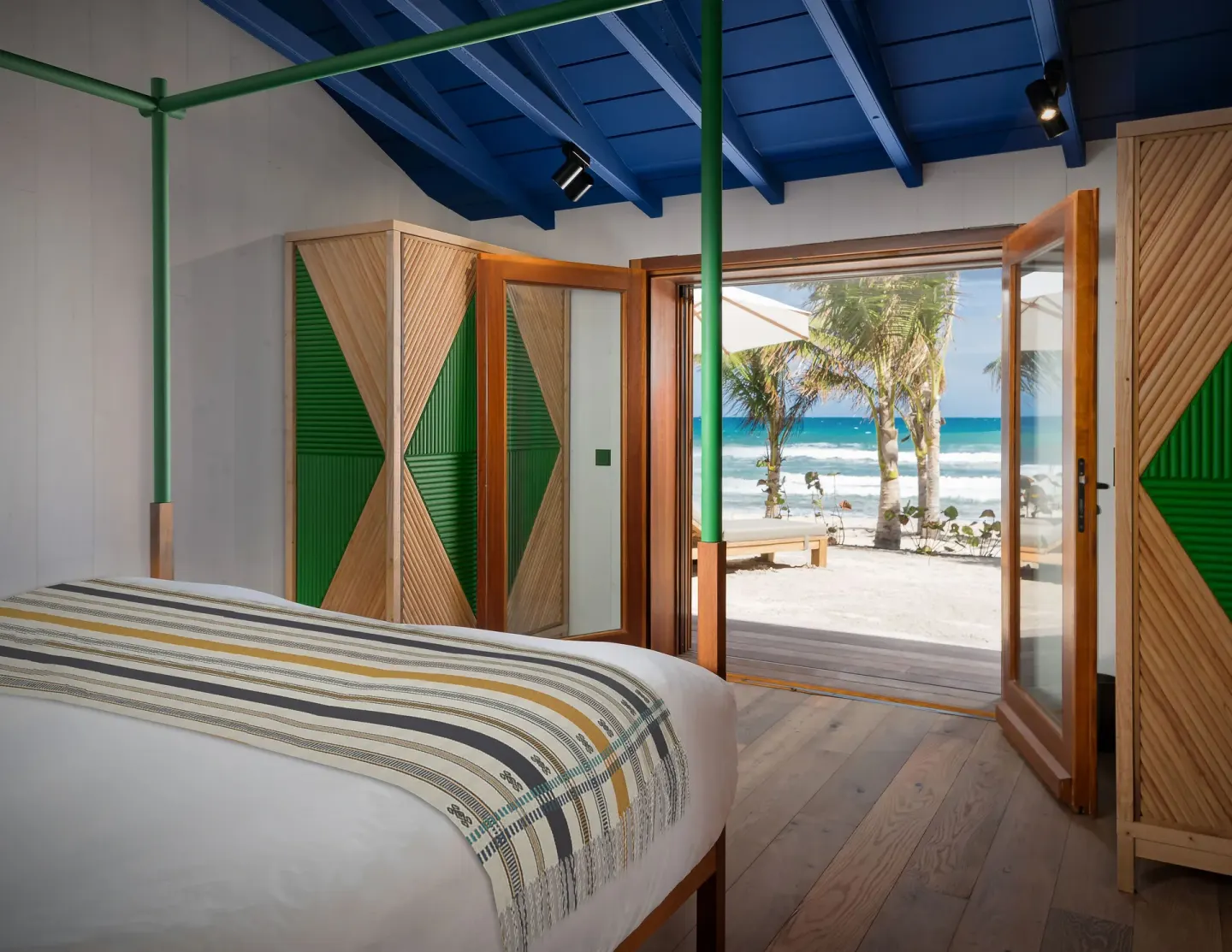 Beachside Suite bedroom with ocean-facing doors at Hotel Manapany.